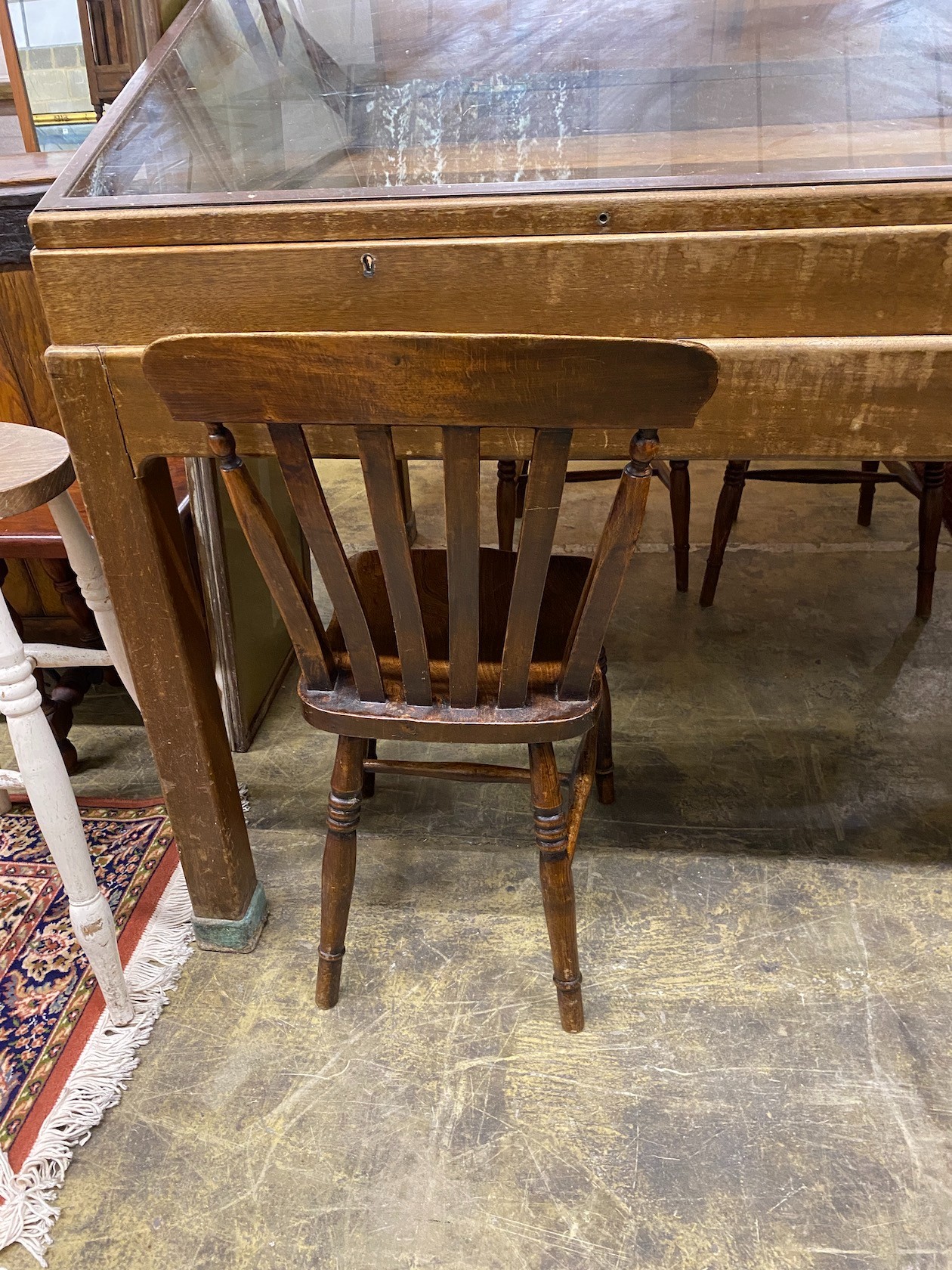 A set of six Victorian elm and beech Windsor lathe back kitchen chairs together with a circular part painted elm stool
